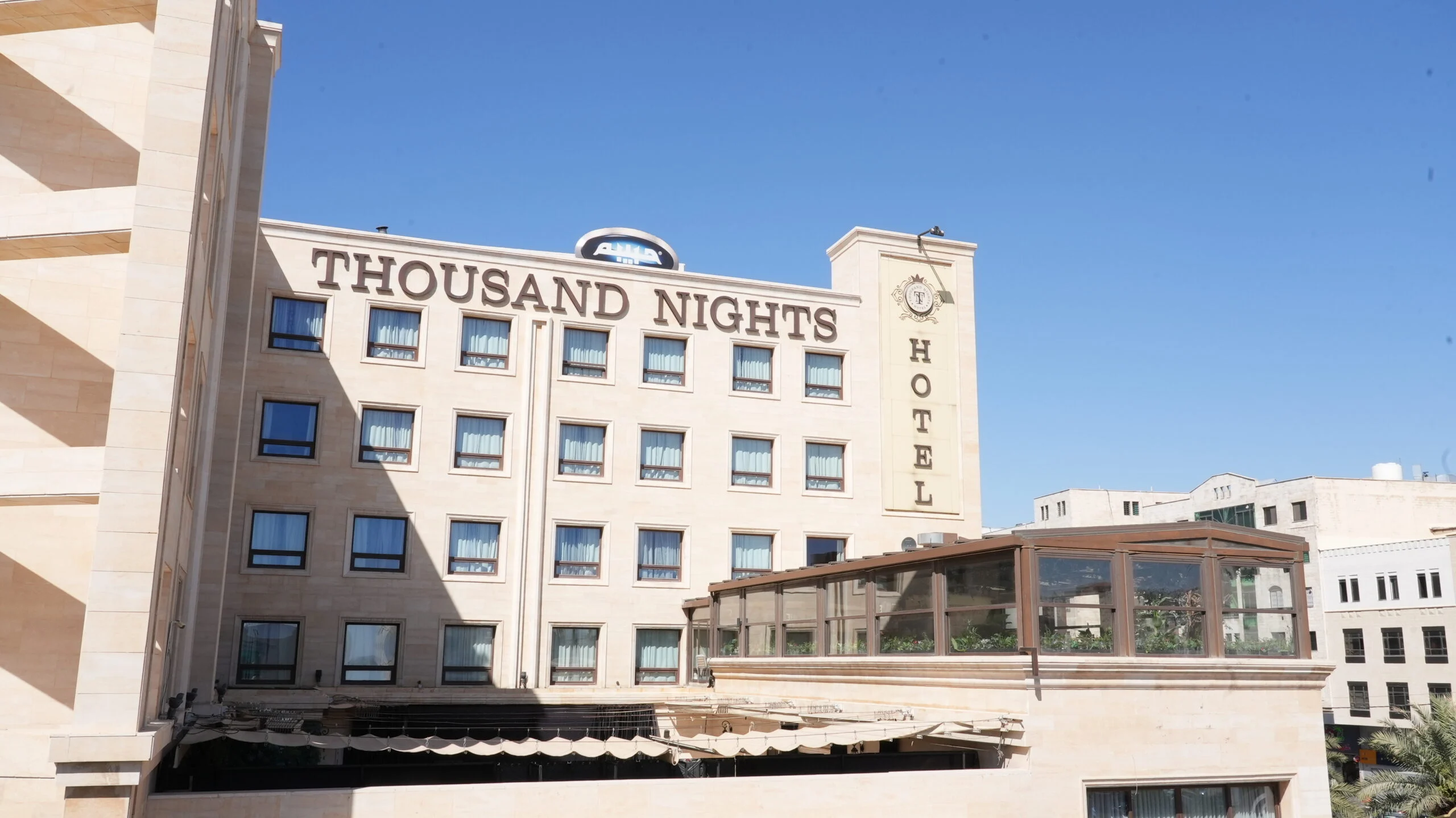 Thousand Nights Hotel facade with its rooftop sign, Amman